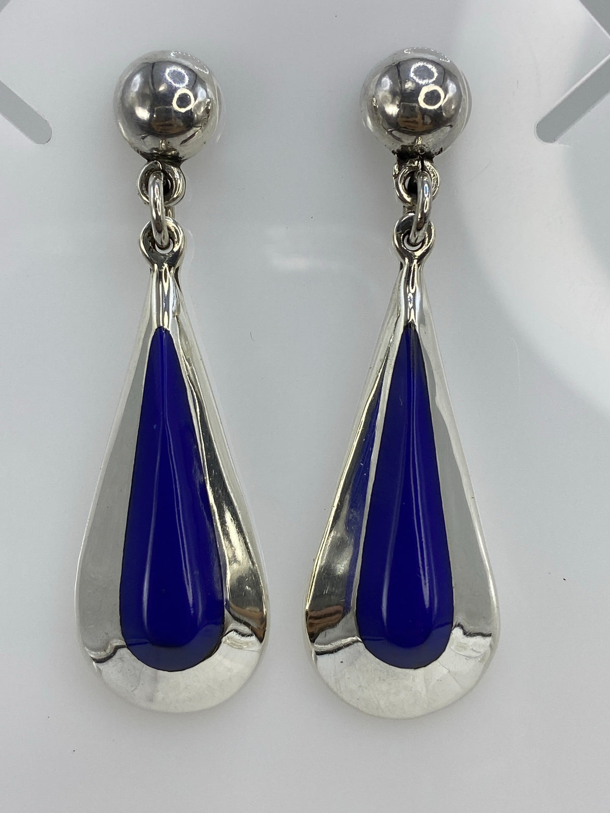 Par de aretes de plata con lapislázuli azul colgando, vista frontal