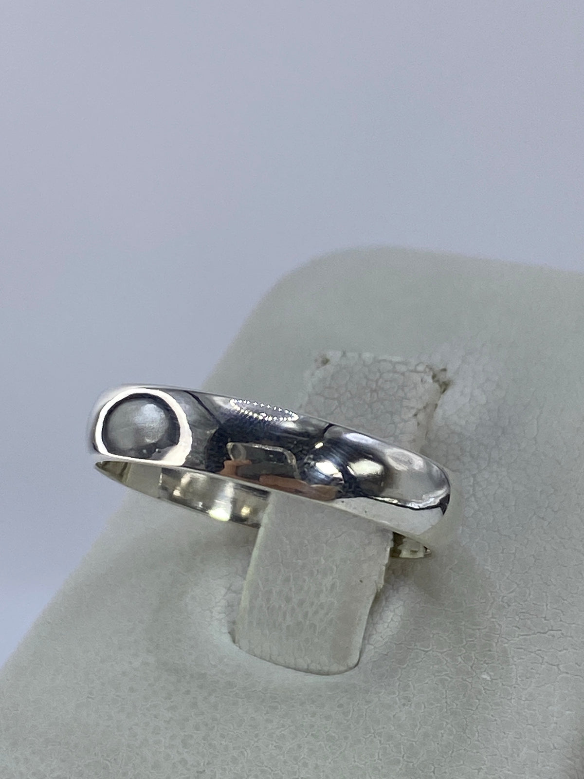 Vista lateral del anillo de plata unisex mostrando el acabado espejo