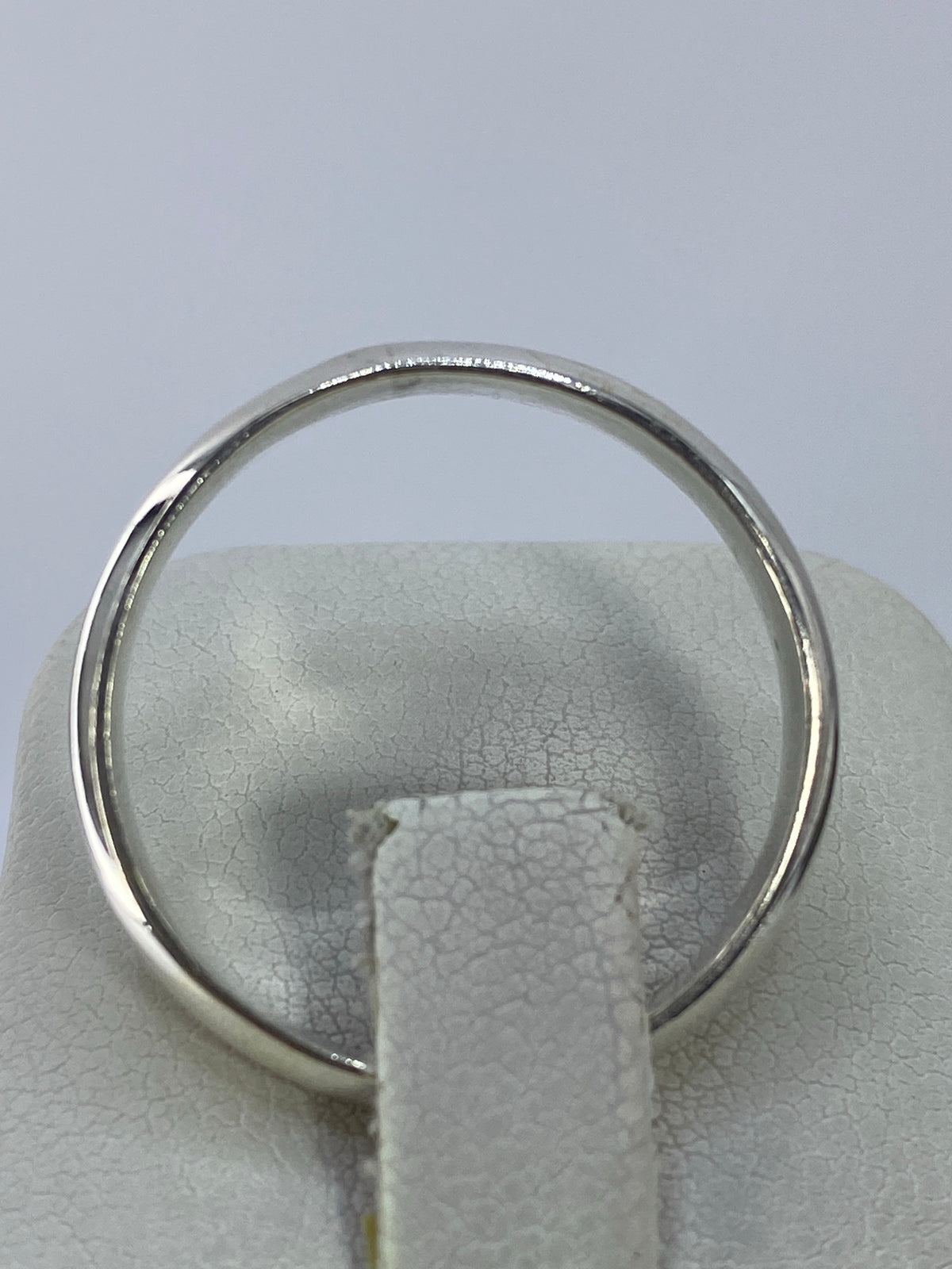 Anillo de plata banda minimalista sobre fondo blanco