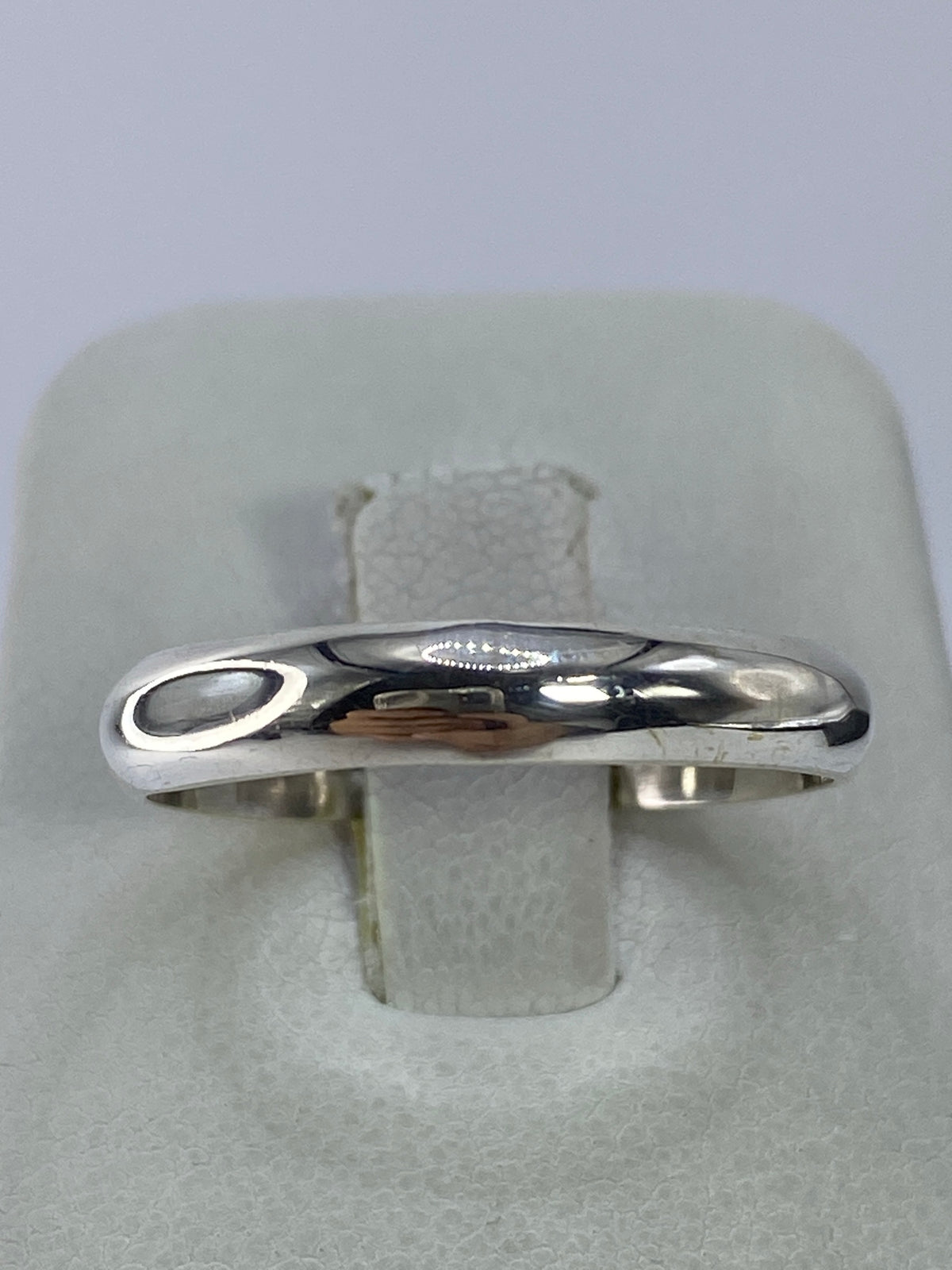 Anillo de plata en la mano mostrando el Quinto 925 grabado