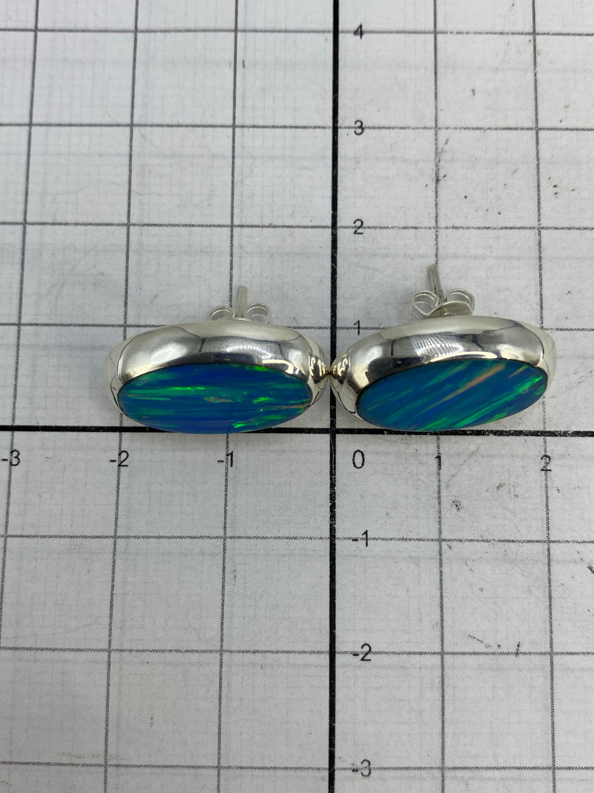 Aretes de ópalo de fuego sobre fondo blanco con marca 925