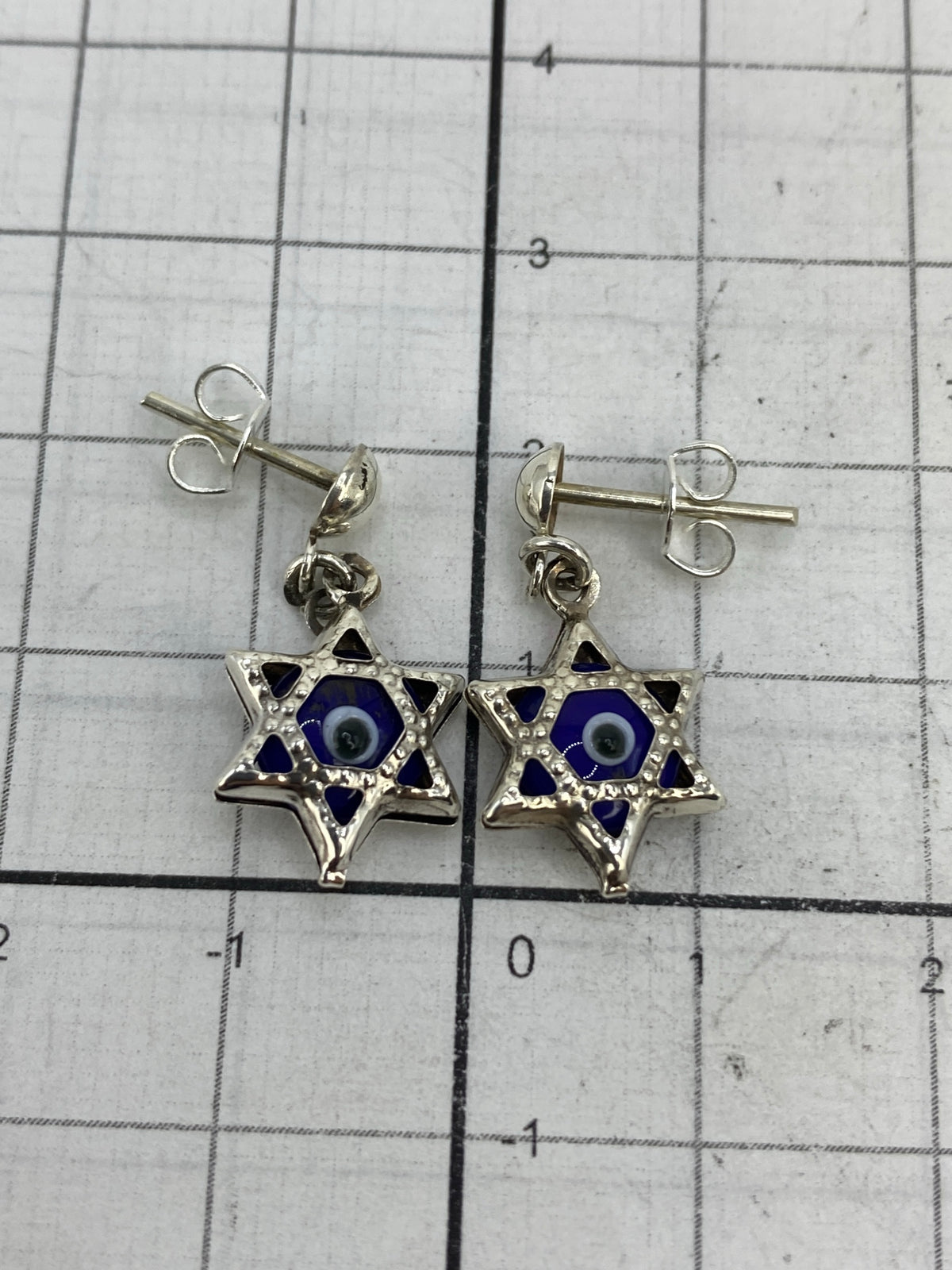 Aretes sobre fondo blanco mostrando el poste de plata 925 y tamaño real (2.3 × 1.2 cm)