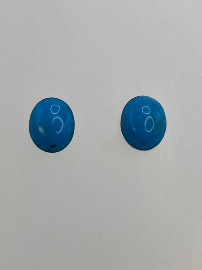 Par de aretes de plata con turquesa azul engastada, vistos de frente