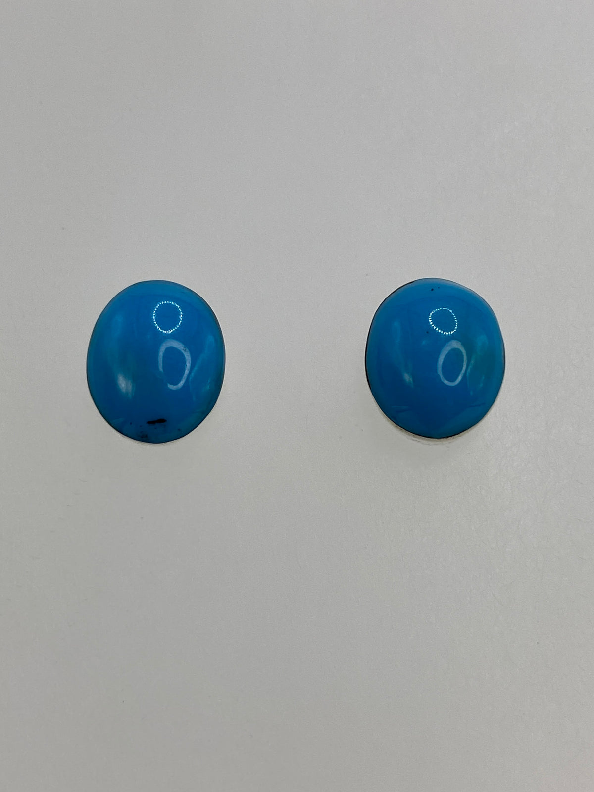Detalle de los aretes mostrando la turquesa azul y el engaste a mano en plata 950