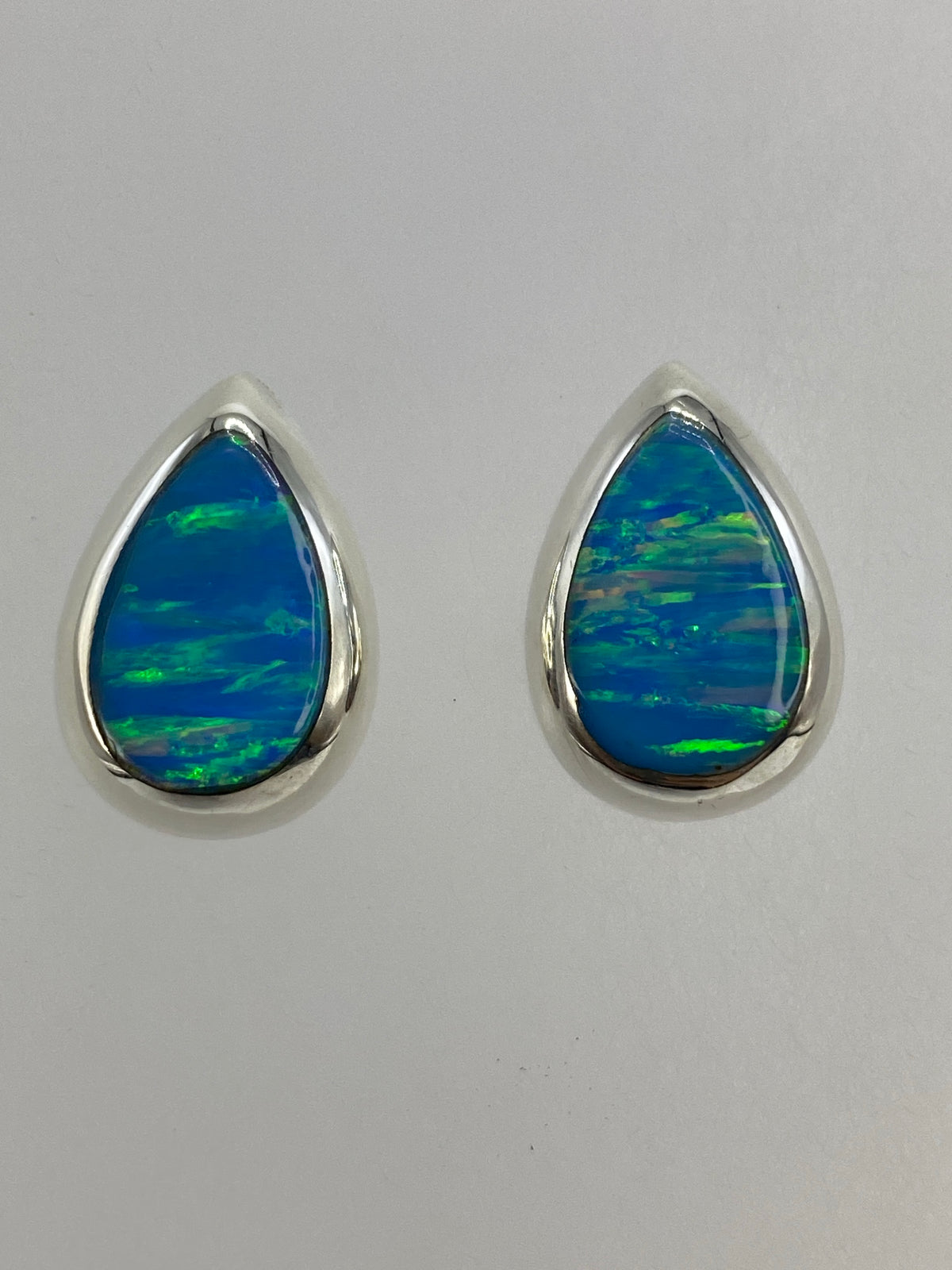 Par de aretes de plata con ópalo de fuego azul cielo engastado, forma de gota minimalista