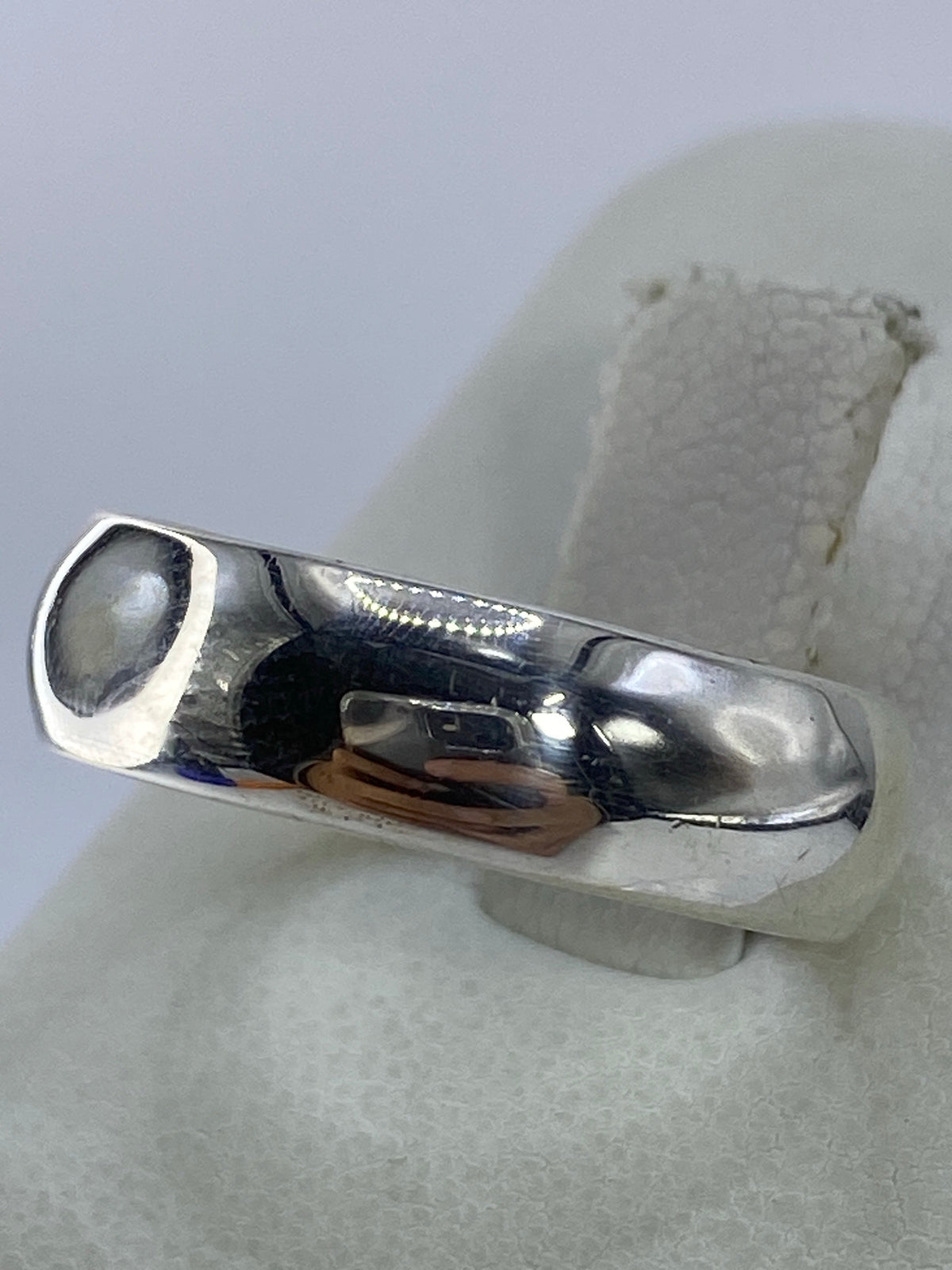 Vista frontal del anillo de plata pulida, banda lisa y brillante