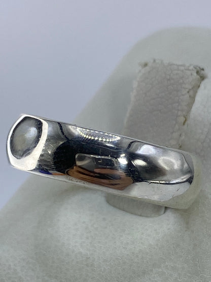 Vista frontal del anillo de plata pulida, banda lisa y brillante