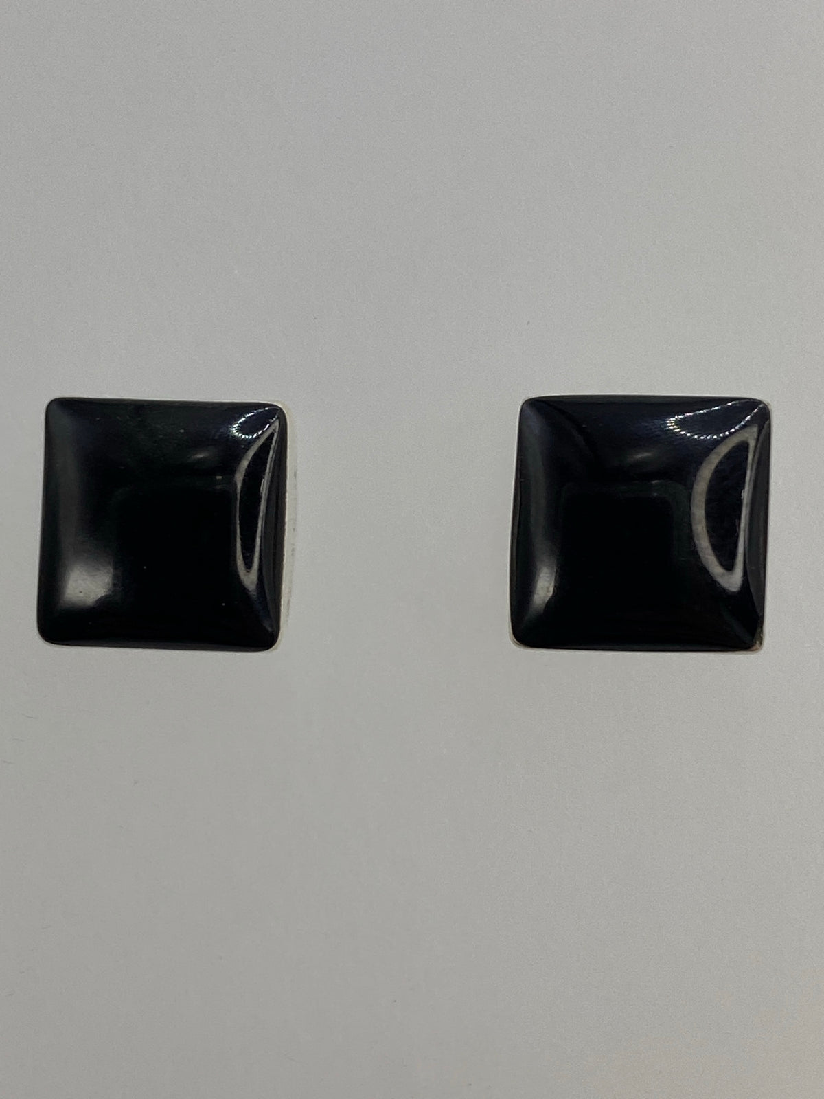 Los dos aretes juntos con los postes de plata y tuercas de seguridad visibles