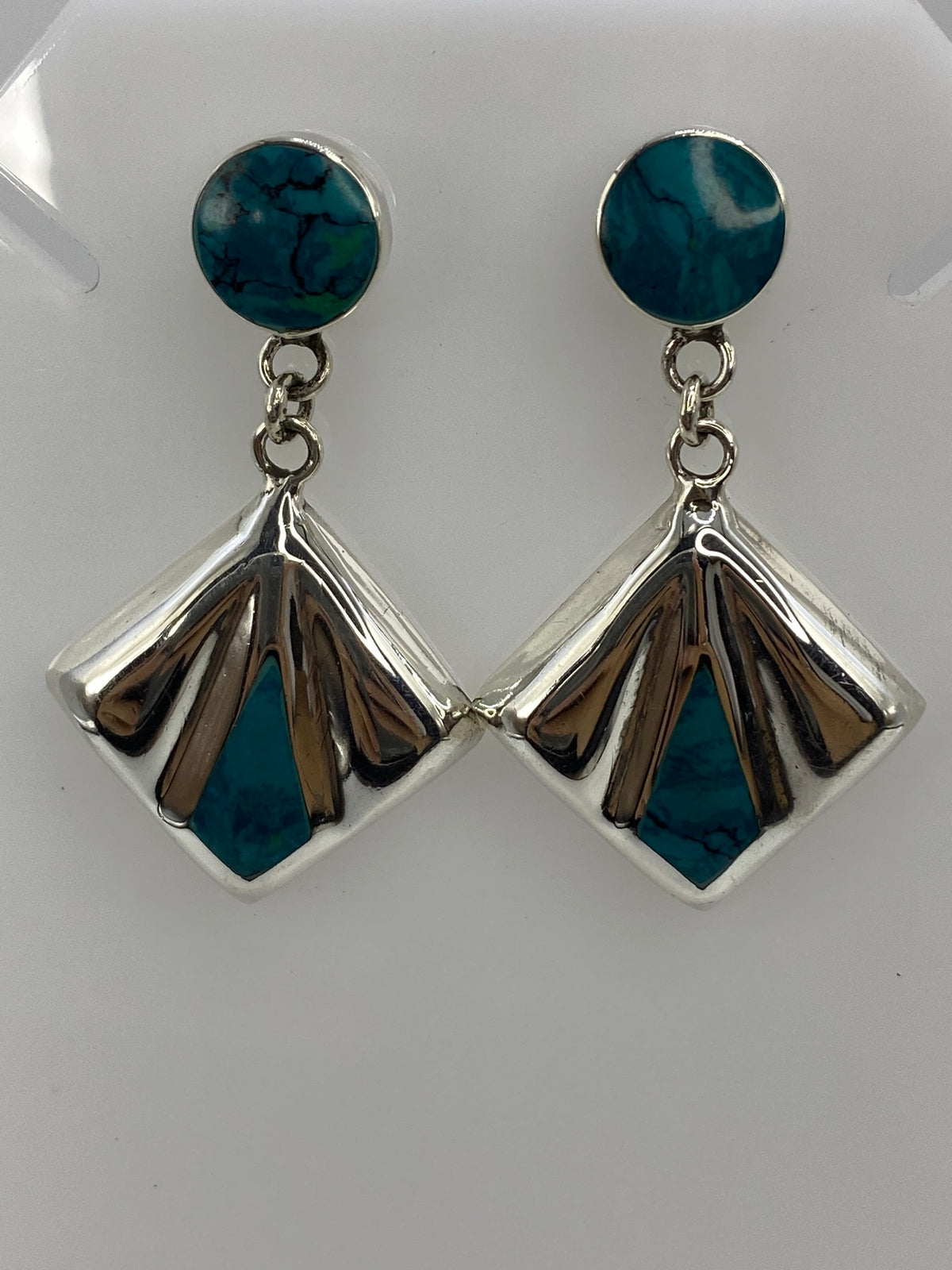 Par de aretes de plata en forma de abanico con turquesa azul incrustada, colgando de poste de plata
