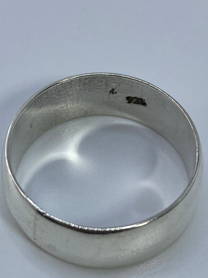 Anillo de plata sobre fondo blanco con reflejo del acabado pulido