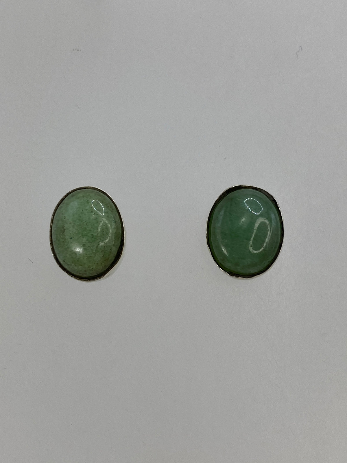 Aretes de plata 950 con lapislázuli verde sobre fondo azul, mostrando el tamaño compacto
