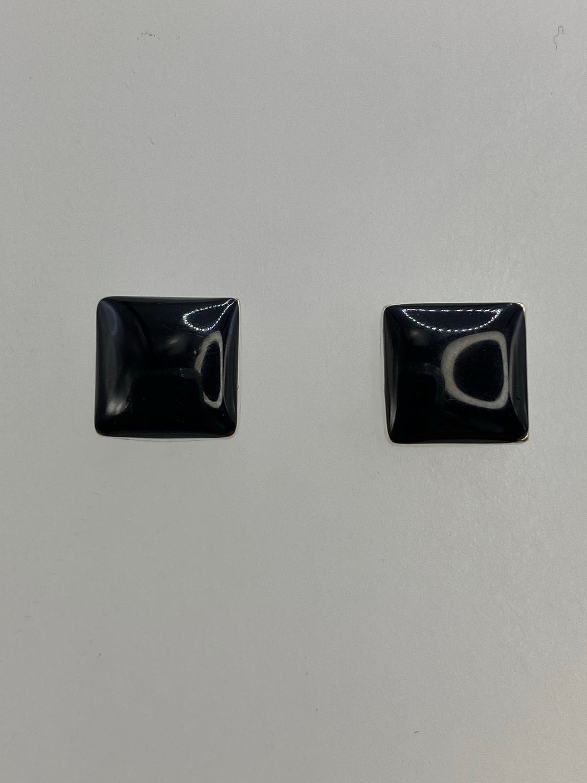 Par de aretes de plata 950 con ónix negro cuadrado sobre fondo blanco