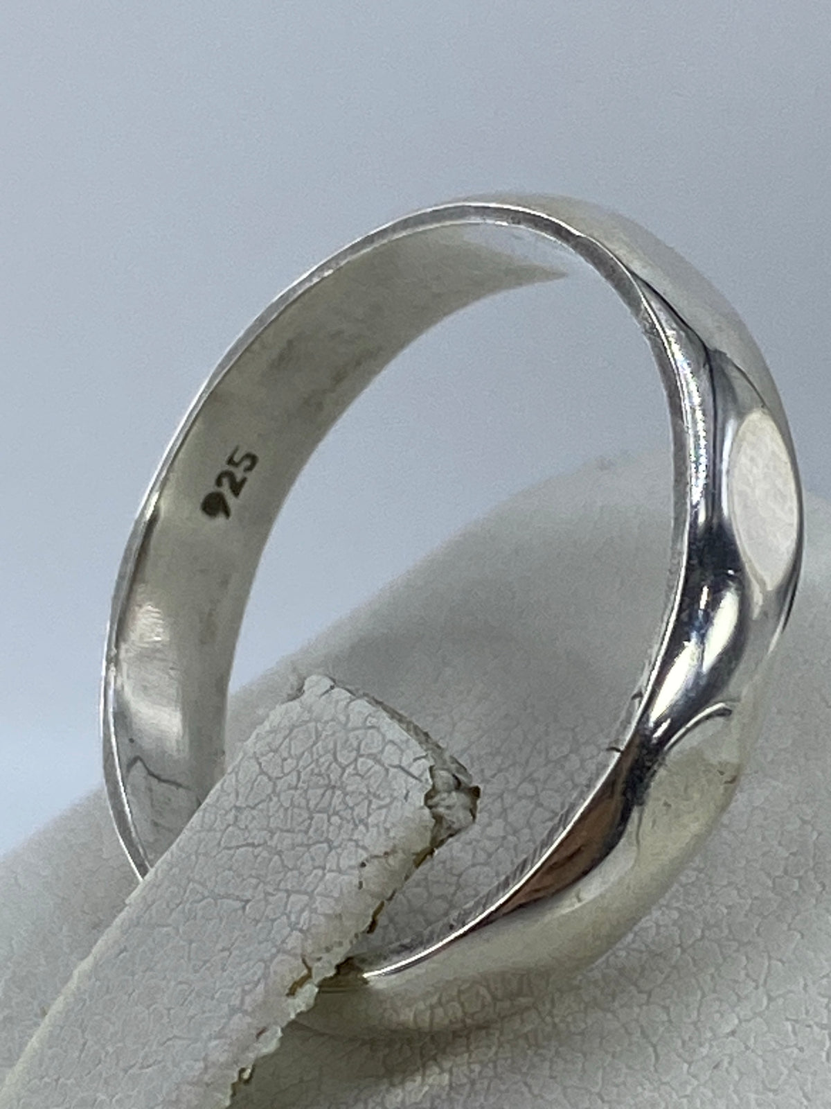 Anillo de plata puesto en dedo, mostrando el acabado pulido brillante