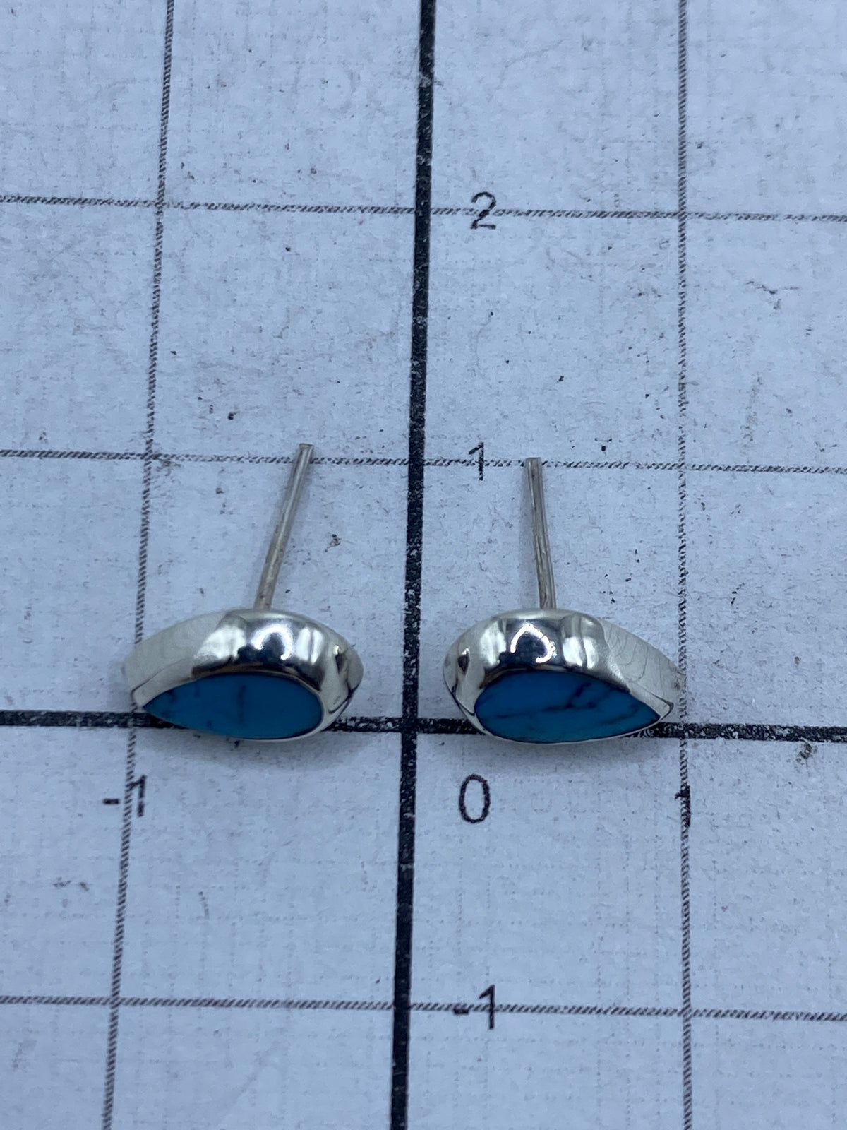 Reverso de los aretes mostrando el engaste a mano y la plata auténtica