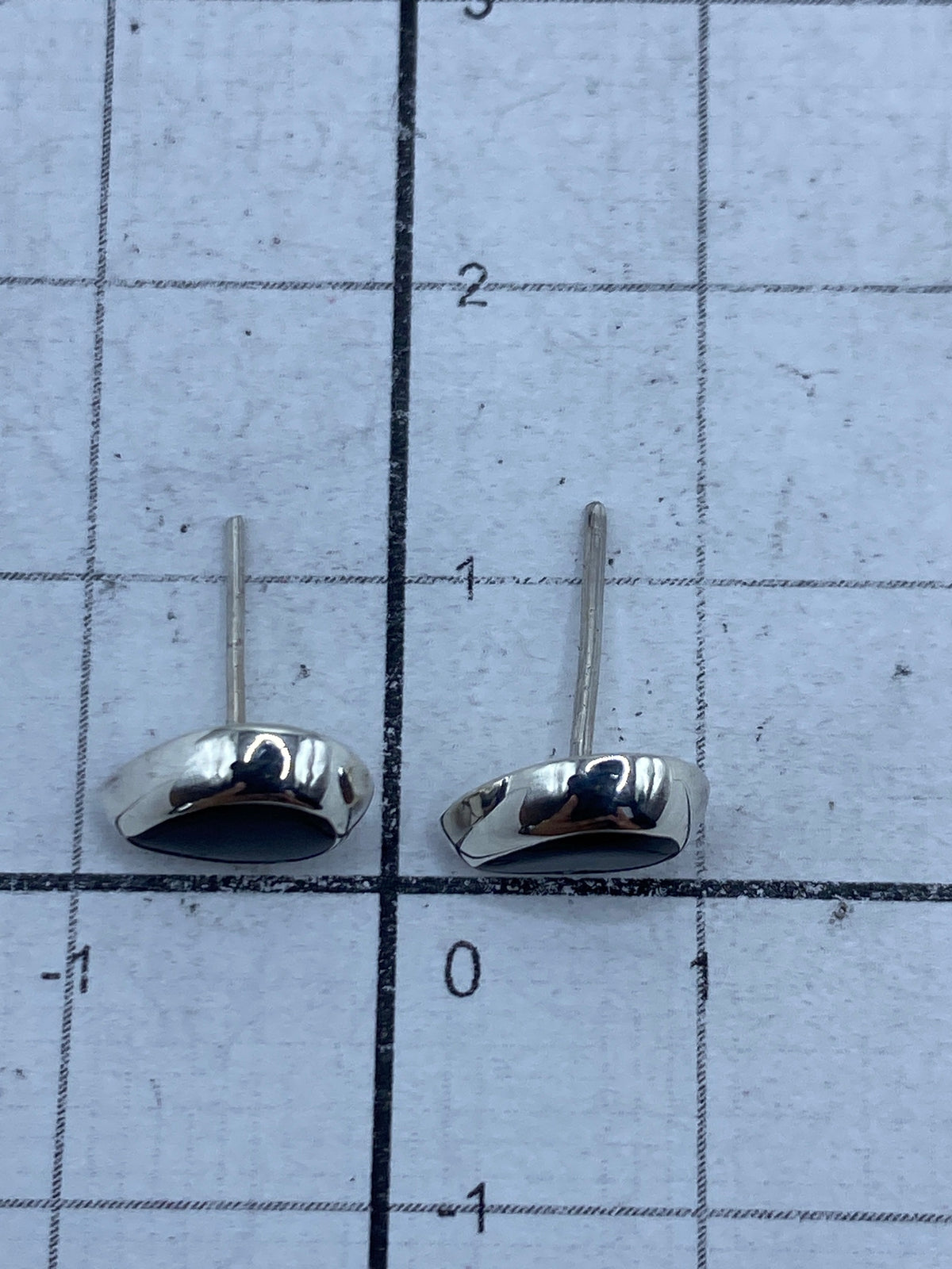 Reverso de los aretes de plata 925 con ónix, visible el cierre de tuerca y Quinto