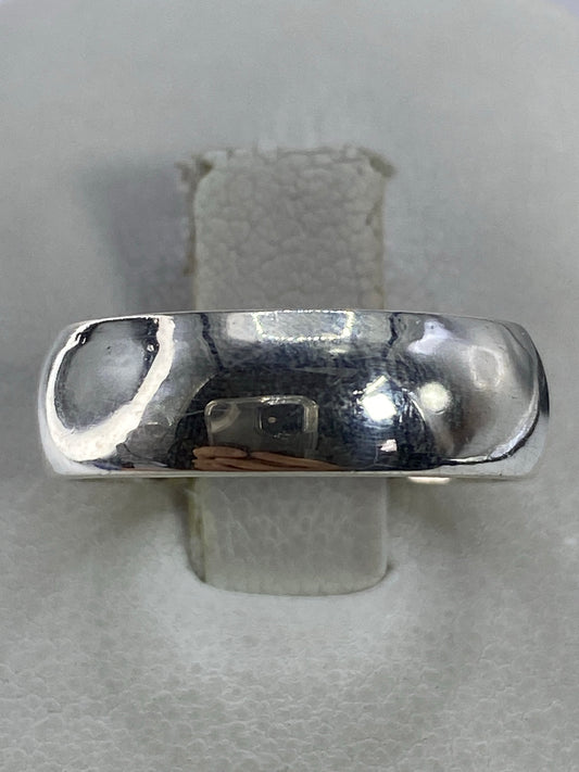 Anillo de plata 925 minimalista pulido en la mano, banda lisa y brillante