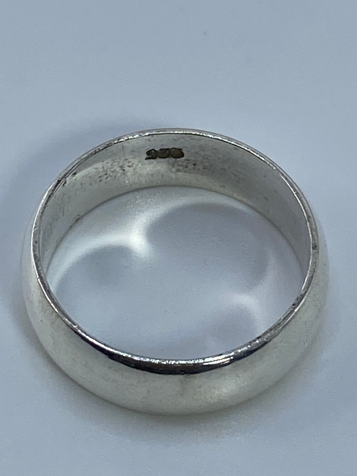 Anillo de plata puro sobre fondo blanco resaltando su brillo