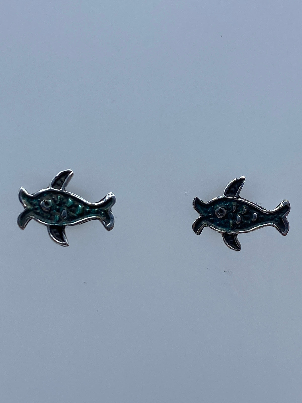 Par de aretes de plata repujados en forma de tortuga marina, vista frontal
