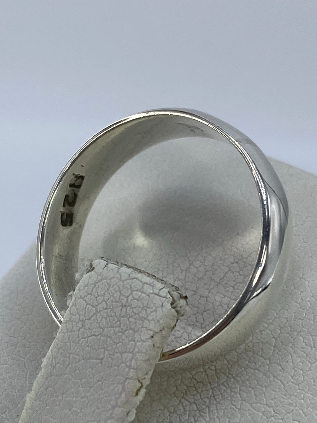 Anillo de plata minimalista puesto en dedo, brillante y perfecto