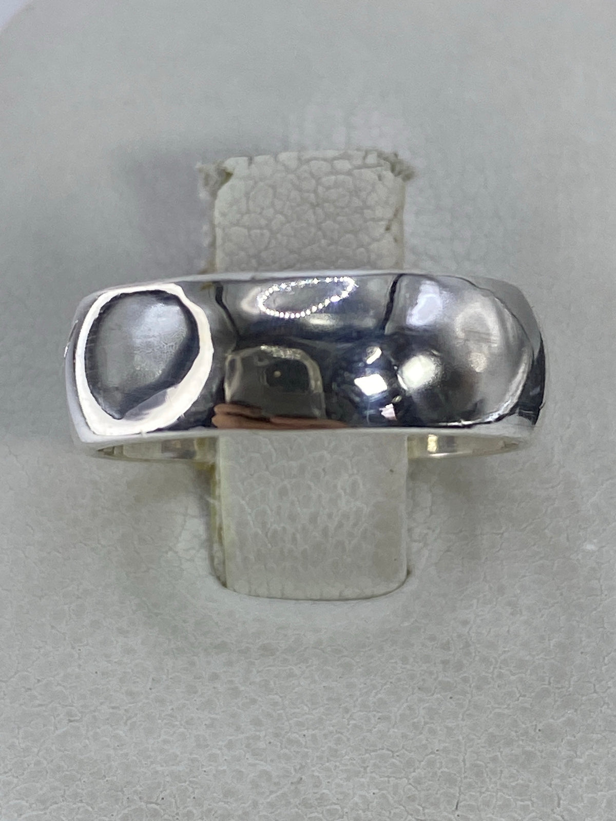 Anillo de plata 925 pulido en banda clásica, vista superior sobre fondo gris