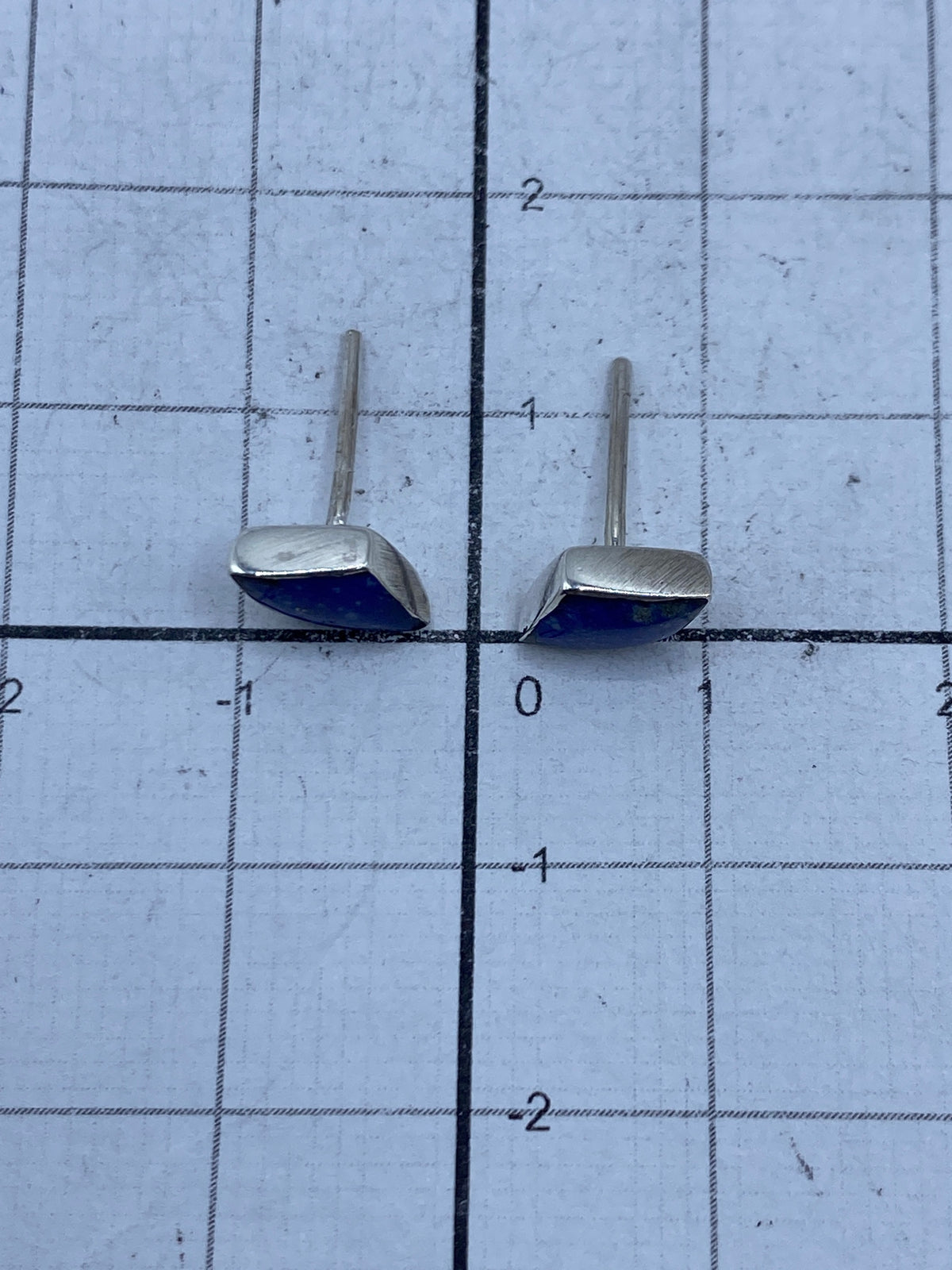 Dos aretes de plata 925 con lapislázuli lado a lado sobre fondo blanco
