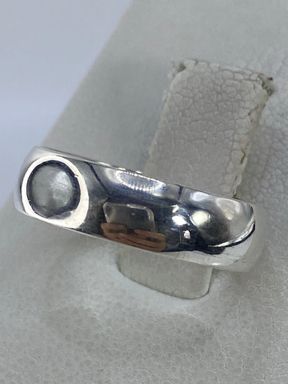 Anillo brillante en plata 925 con acabado pulido, vista lateral sobre papel texturado