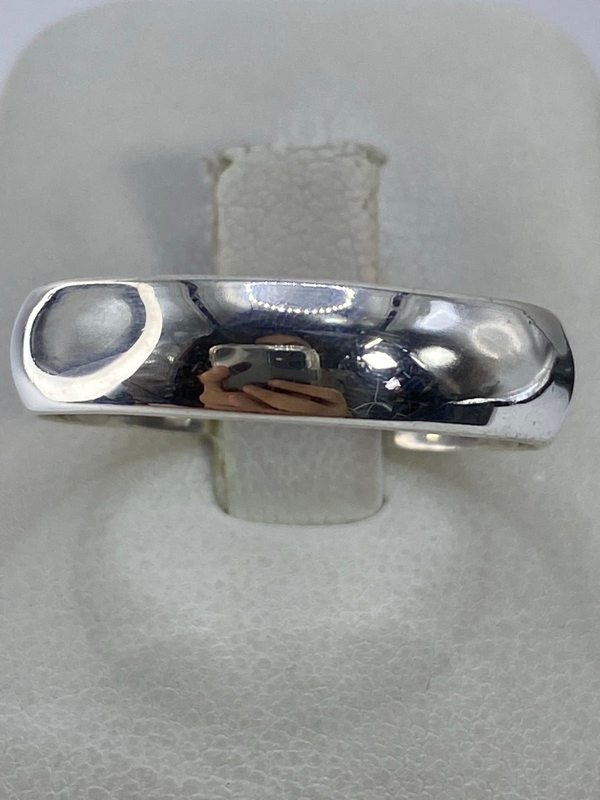 Anillo de plata 925 pulida con banda lisa en mano de mujer