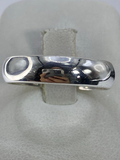 Anillo de plata 925 pulida con banda lisa en mano de mujer