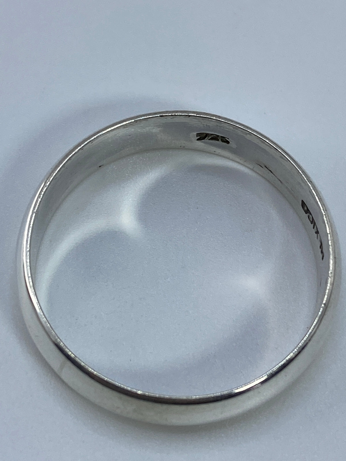 Anillo sobre fondo blanco mostrando el acabado liso y brillante
