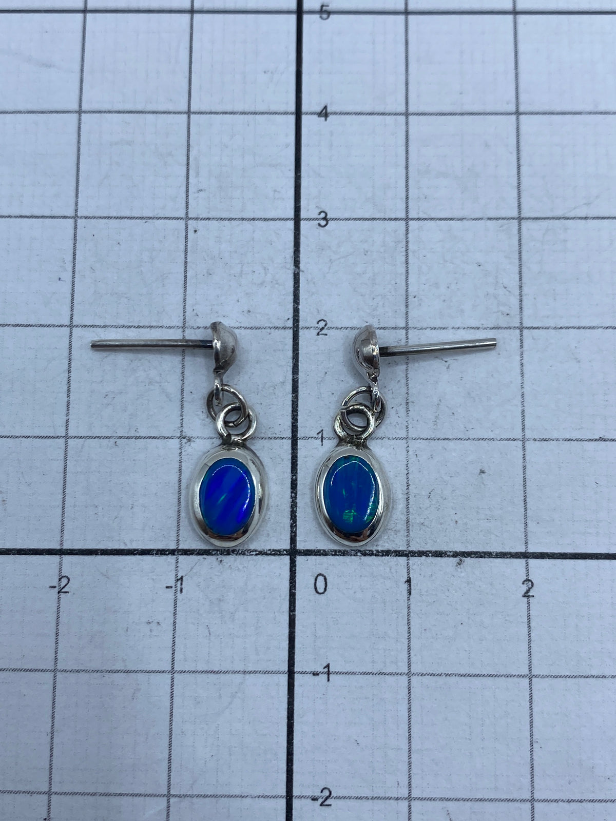 Aretes con poste y mariposa, vista frontal del ópalo de fuego azul
