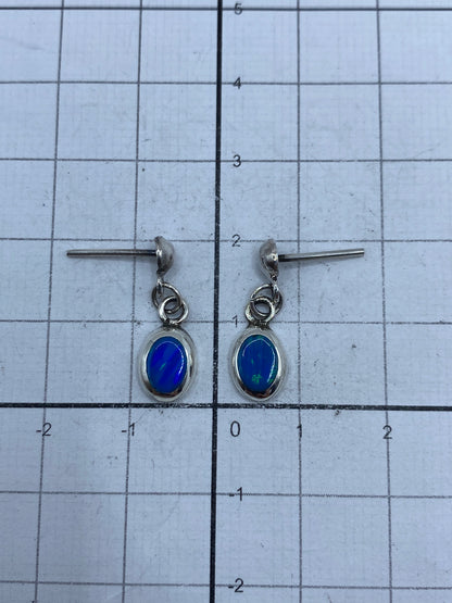 Aretes con poste y mariposa, vista frontal del ópalo de fuego azul