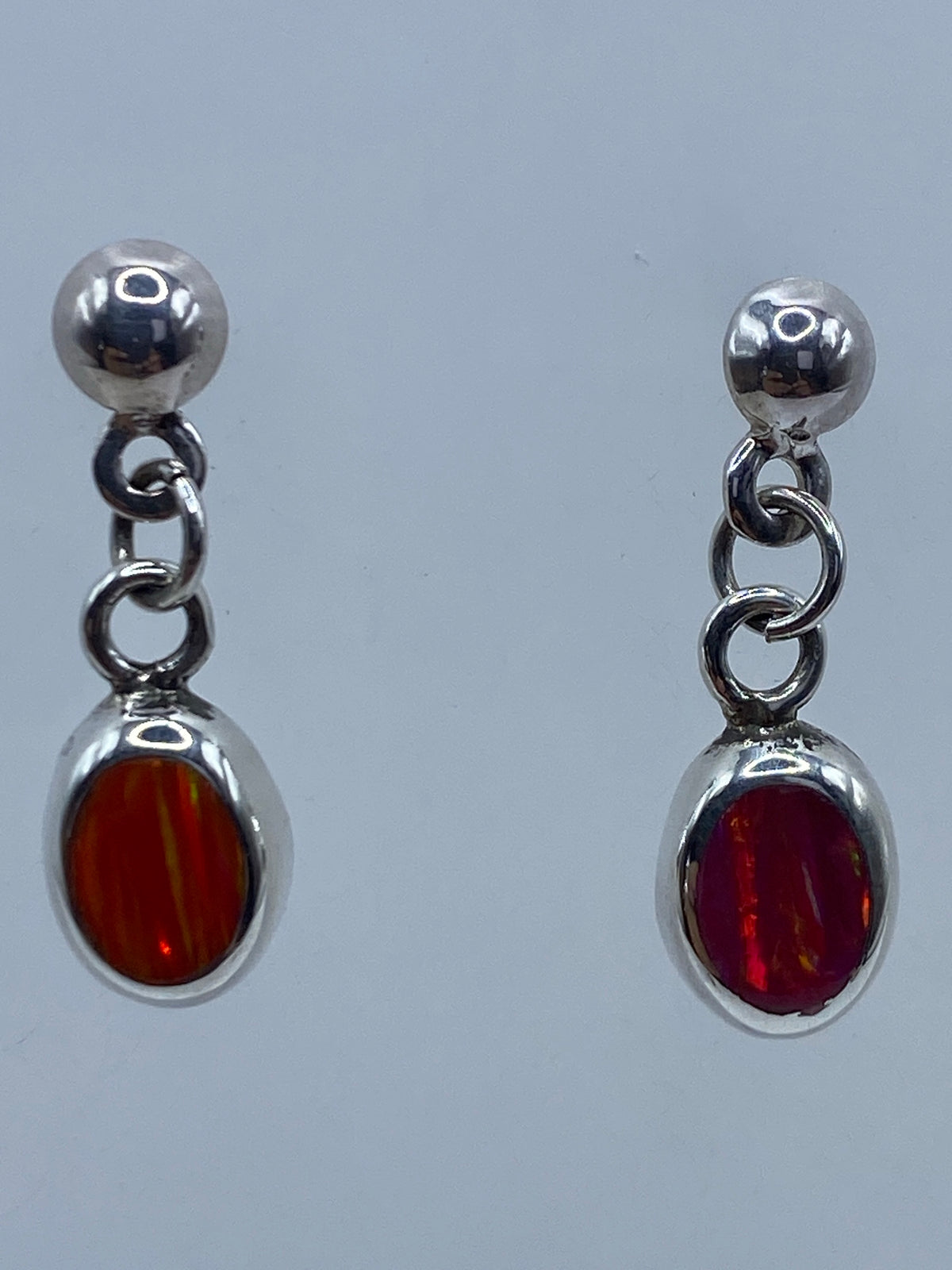 Par de aretes de plata 925 con ópalo de fuego multicolor engastado, vistos desde arriba