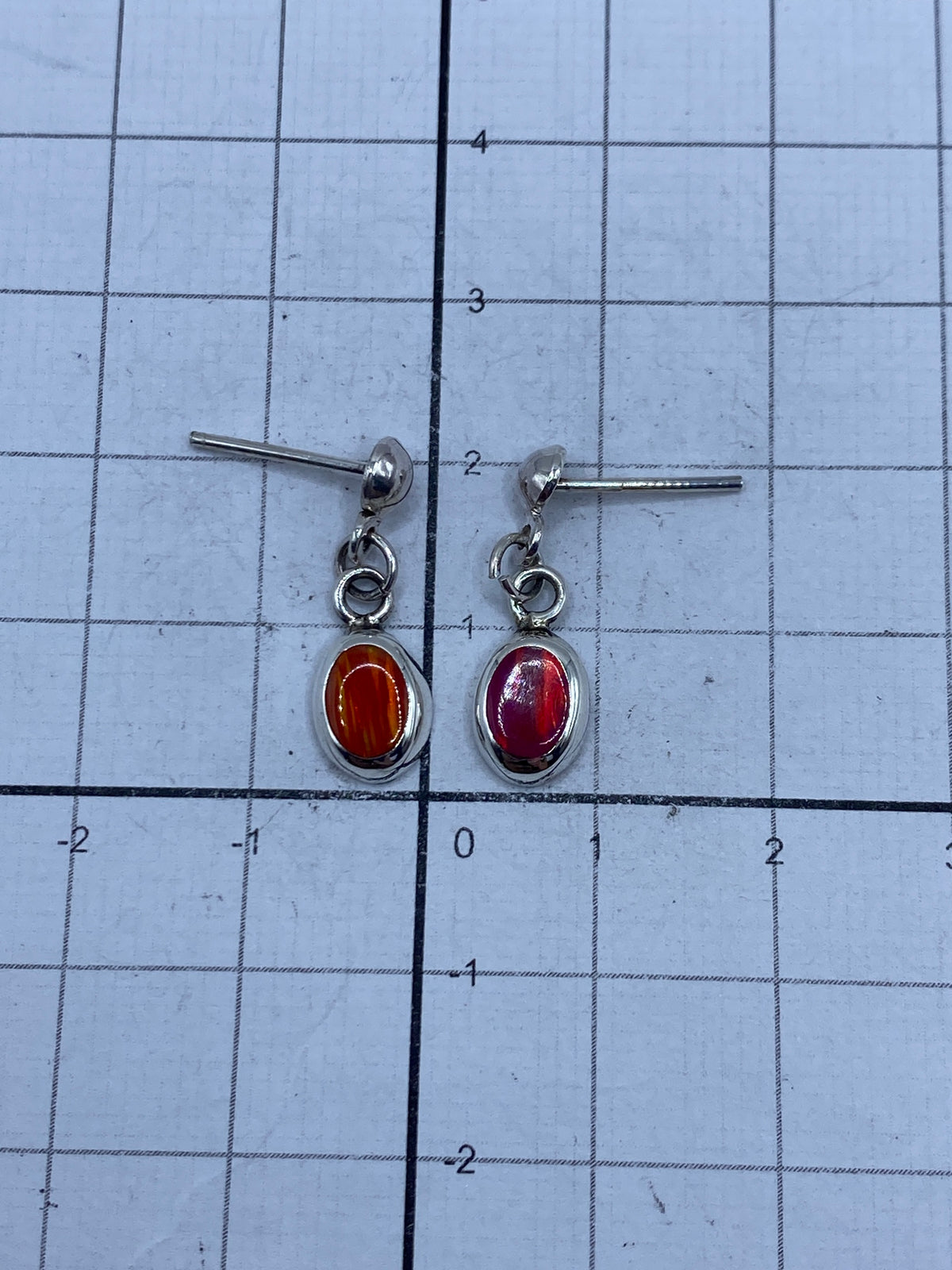 Aretes de ópalo de Taxco sobre medidor de escala, mostrando su tamaño delicado de 2 cm