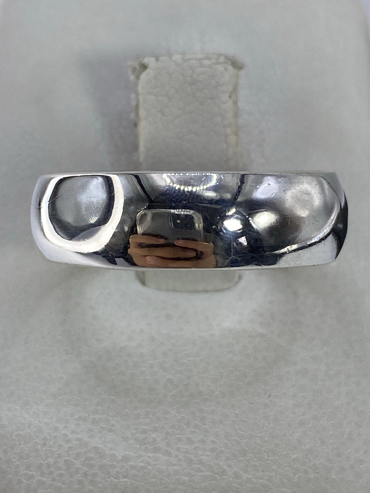 Anillo de plata 925 banda clásica pulida en la mano de una persona