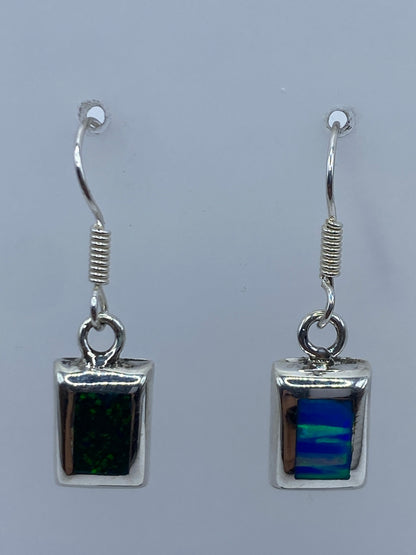 Par de aretes de plata con ópalo de fuego azul engastados a mano, vistos de frente