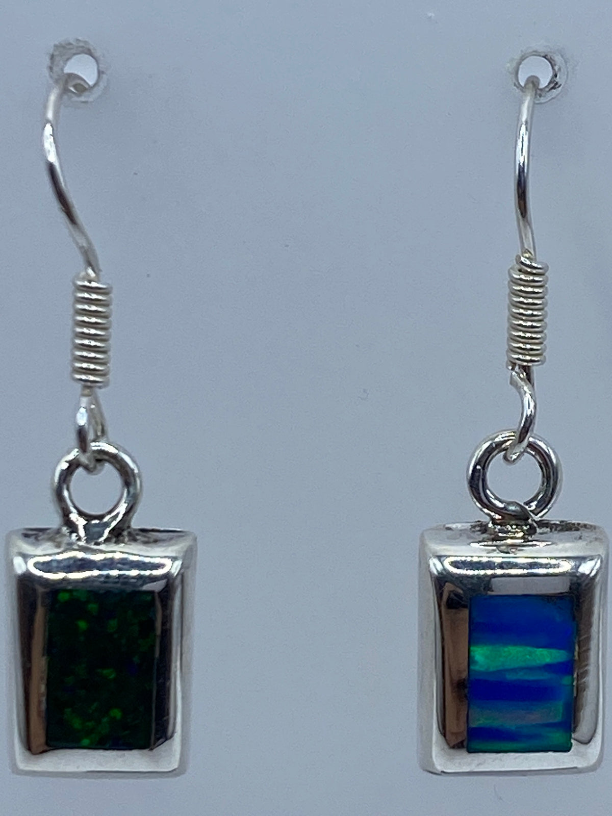 Aretes sobre regla de medida mostrando largo de 2.4 cm