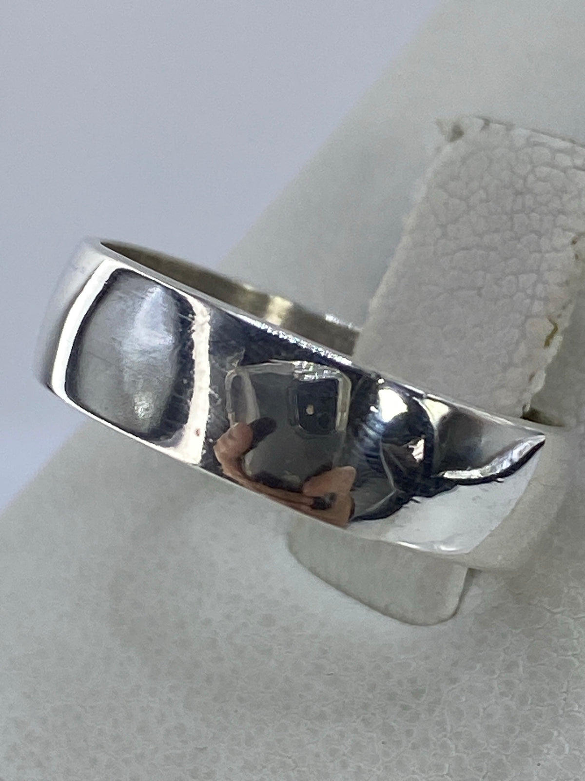 Anillo de plata pulido desde el lateral, mostrando el acabado brillante
