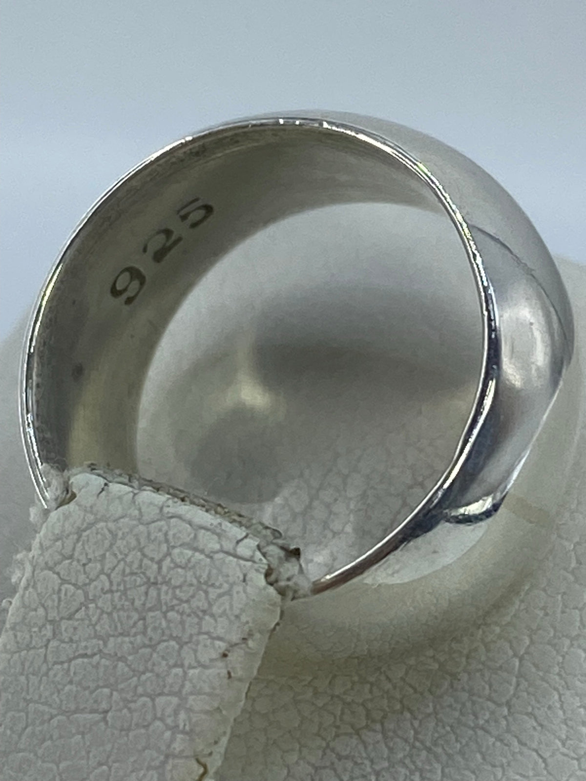Anillo de banda de plata en la mano, mostrando el brillo pulido