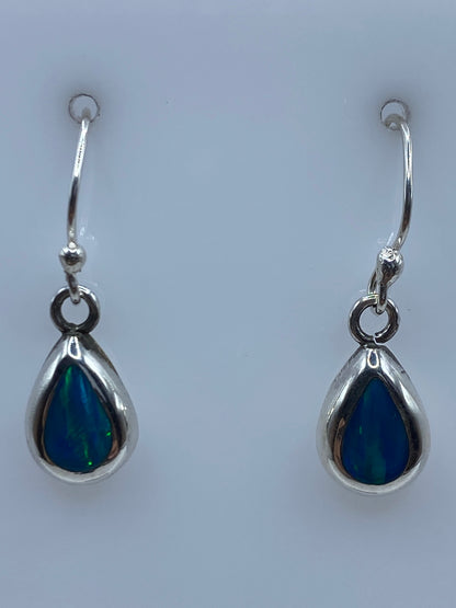 Par de aretes de plata 950 con ópalo de fuego azul, gancho visible, sobre fondo blanco