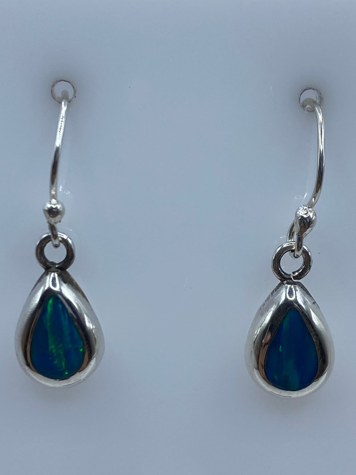 Detalle del ópalo de fuego azul engastado en plata 950, mostrando los destellos verdes