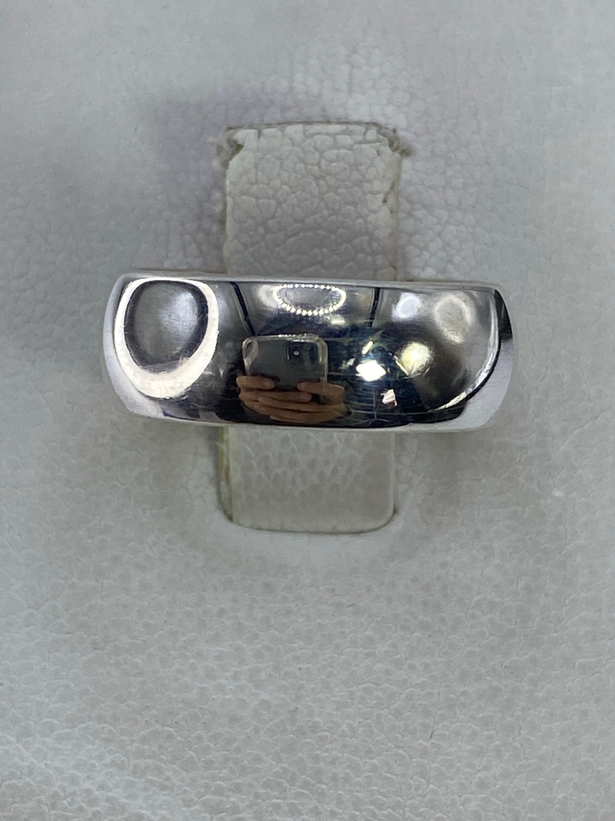Anillo de plata 925 minimalista pulido en la mano, vista frontal brillante