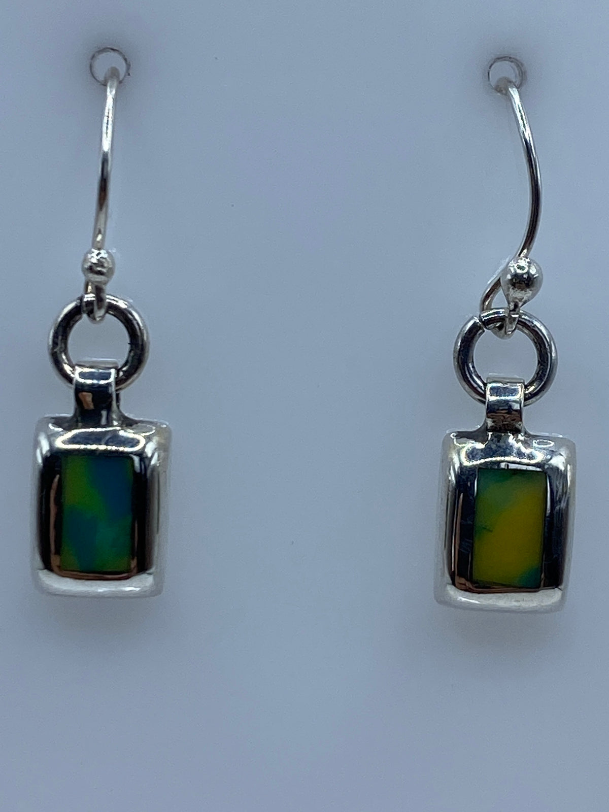 Aretes colocados sobre regla de centímetros, mostrando largo de 2.9 cm