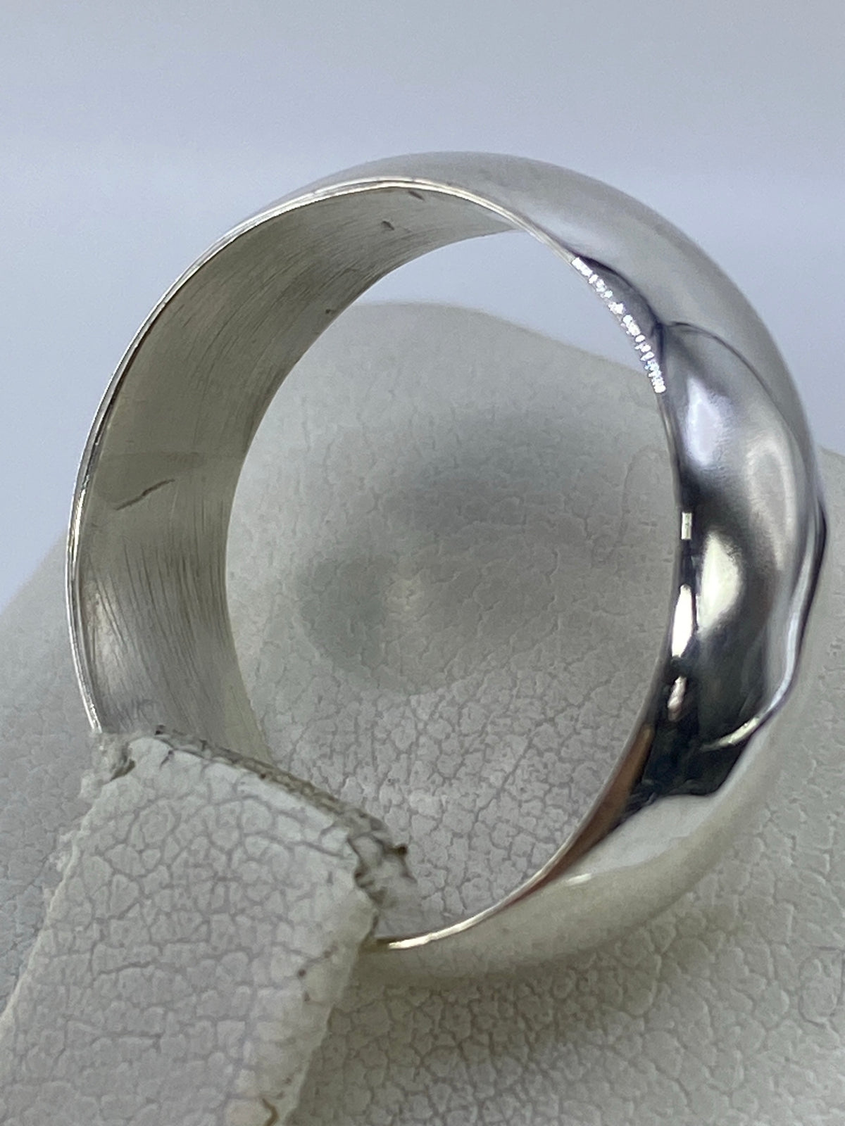 Anillo de plata en la mano, mostrando el brillo y la calidad del pulido
