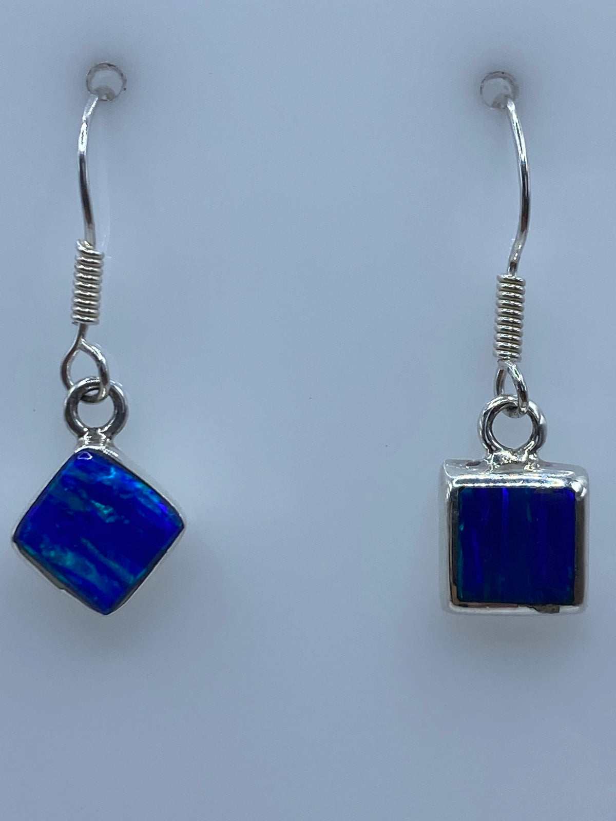 Aretes en la oreja de una mujer, luciendo el azul profundo del ópalo