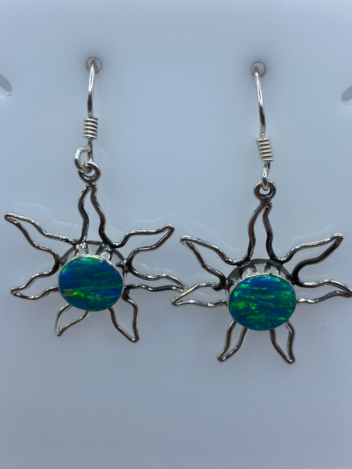 Arete individual de plata 950 con ópalo azul engastado, visto de frente