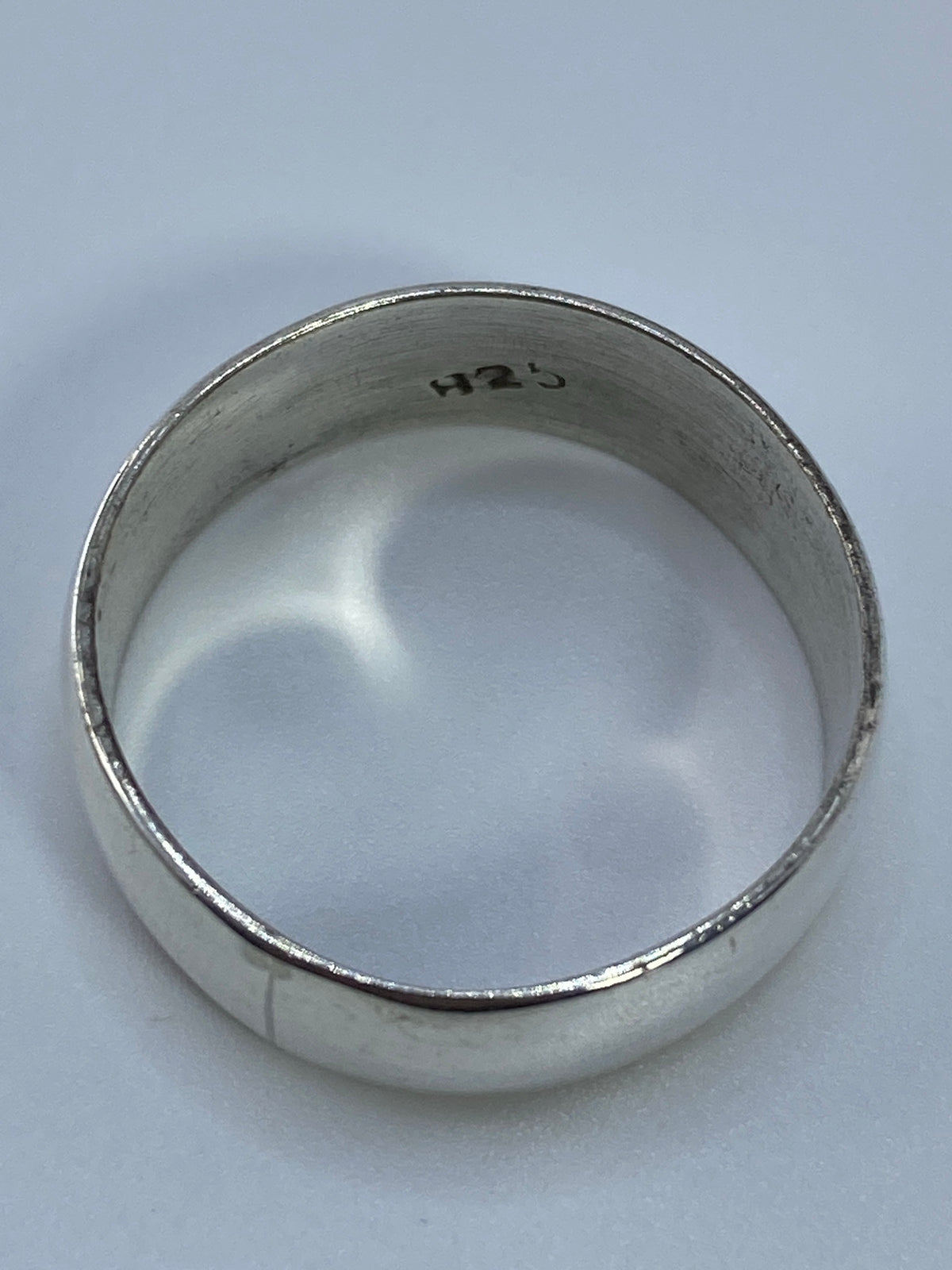Anillo puesto en dedo, mostrando el brillo pulido de la plata