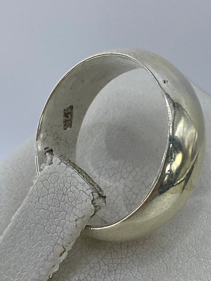 Anillo de plata clásico en la mano, mostrando su brillo