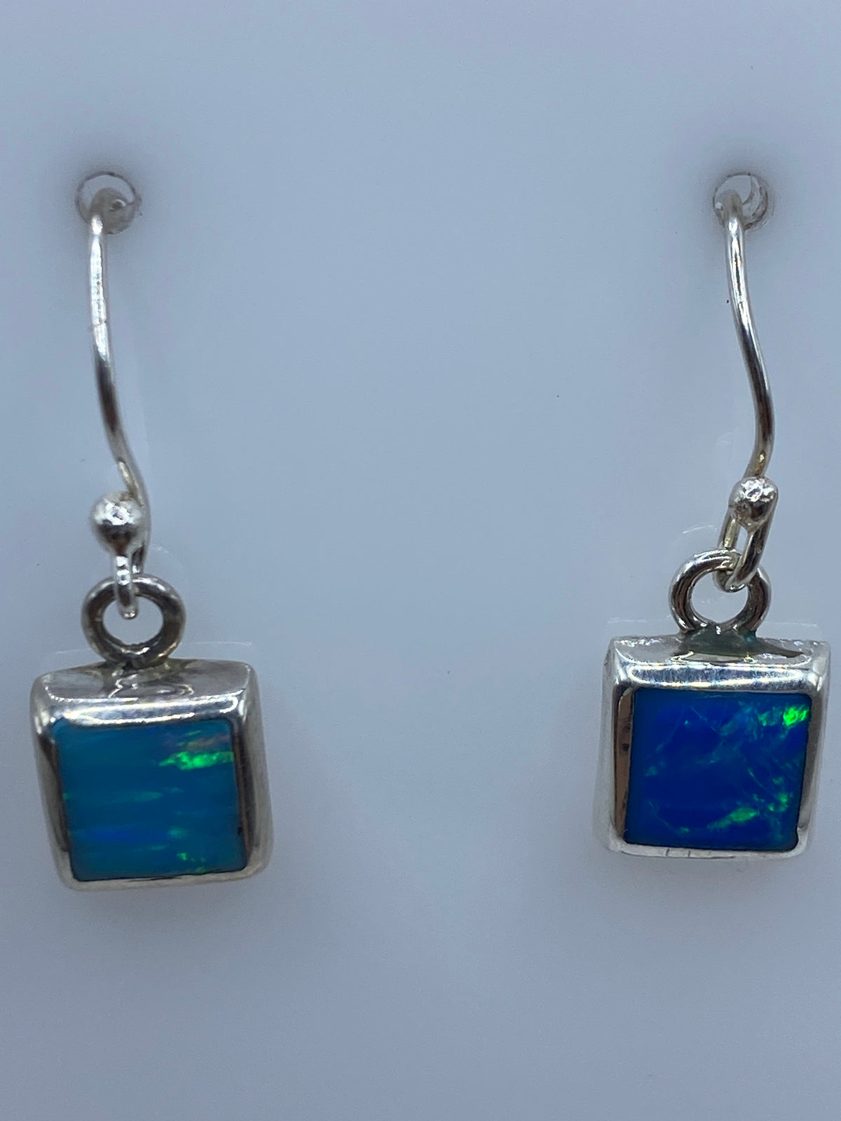 Aretes en el oido mostrando el color azul profundo del opalo