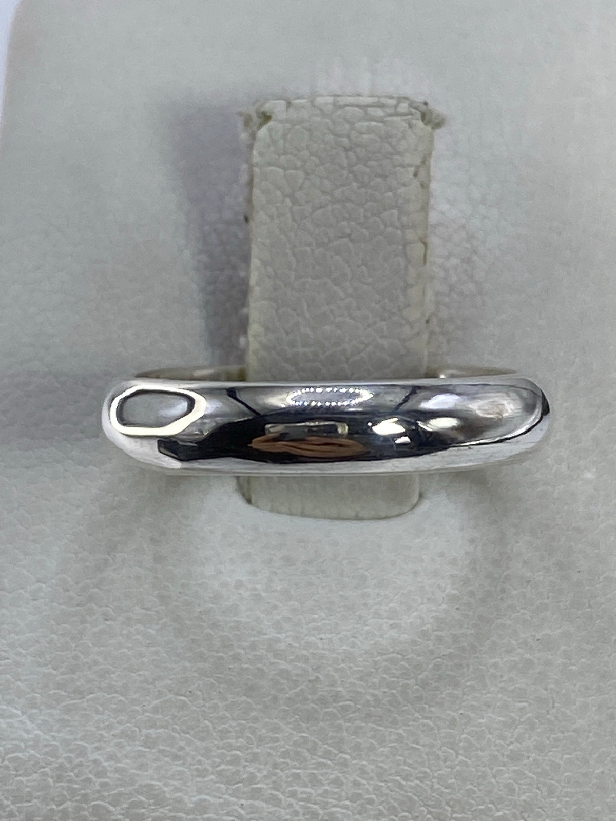 Anillo de plata 925 pulido con acabado espejo en la mano de un hombre