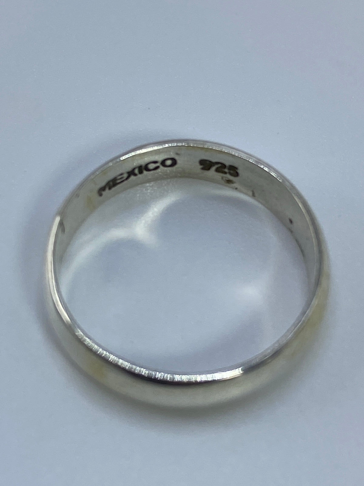 Anillo sobre fondo blanco mostrando el acabado pulido brillante
